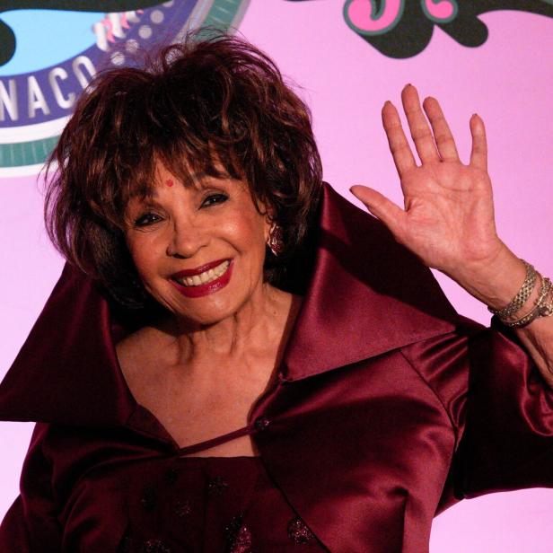 Shirley Bassey lächelt und winkt.
