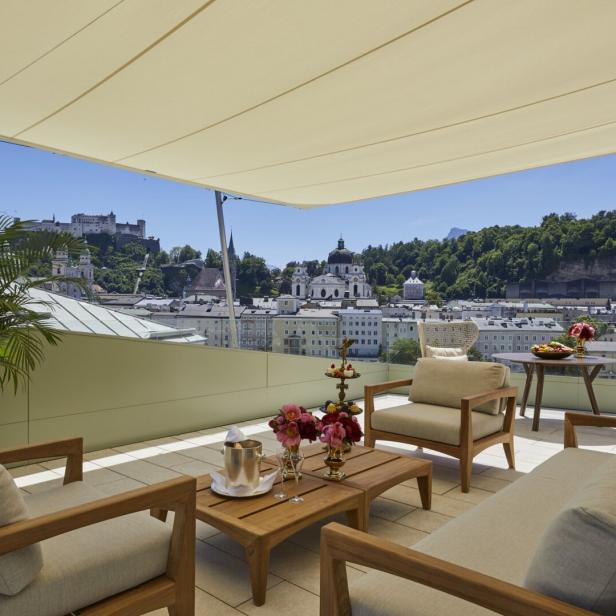 Ein luxuriöser Außenbereich des Hotel Sacher Salzburg mit Blick auf die Stadt.