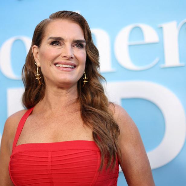Brooke Shields in einem roten Kleid vor dem Hintergrund des Films „Mother of the Bride“.