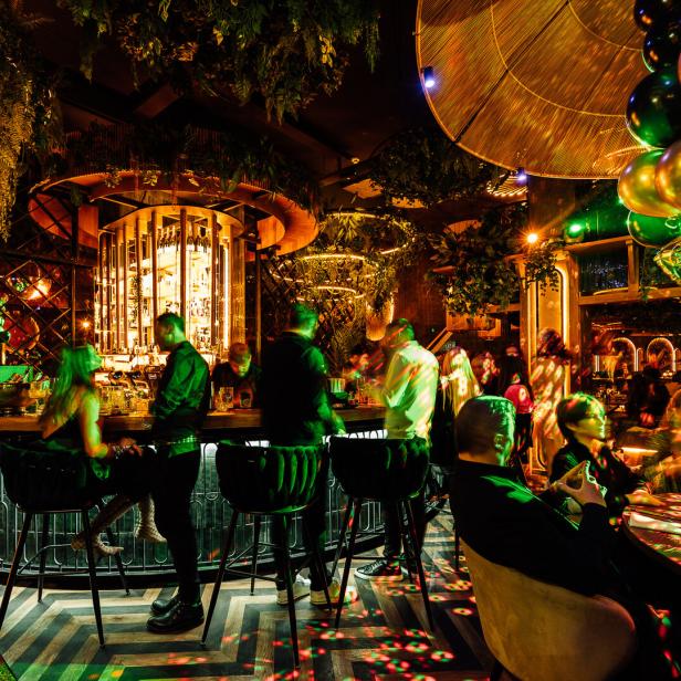 Gäste sitzen und stehen an der Bar des Restaurants Ziizuu.