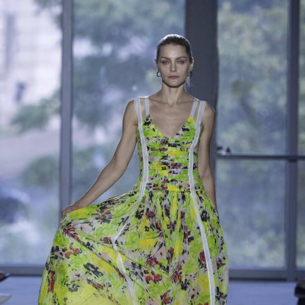 Ein Model präsentiert ein langes, blumengemustertes Kleid.