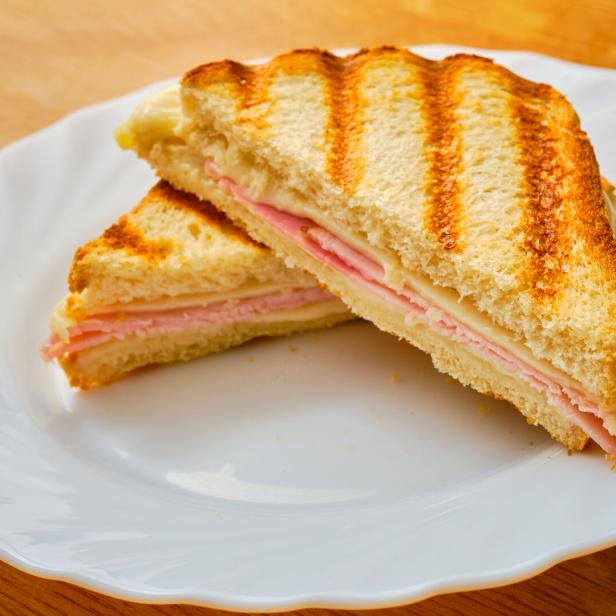 Ein Schinken-Käse-Toast auf einem weißen Teller.