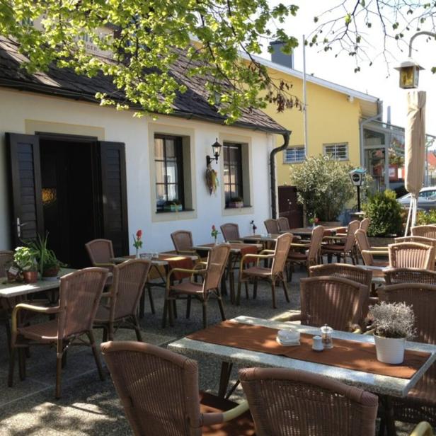 Einladender Außenbereich eines Restaurants mit Tischen und Stühlen.