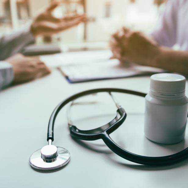 Close up stethoscope and doctor talking the patient at clinic while using the tablet explaining the patient condition and the treatment result.