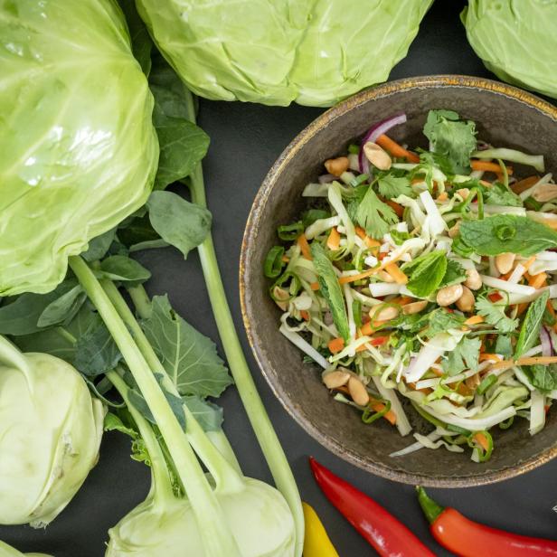 Coleslaw-Salat in einer braunen Schüssel mit Kohl und Kohlrabi rundum