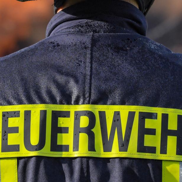Der Schriftzug „Feuerwehr“ auf dem Rücken eines Feuerwehrmannes.