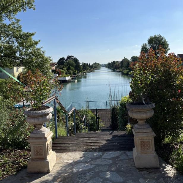 Blick von einer Steintreppe auf einen Kanal an einem sonnigen Tag.
