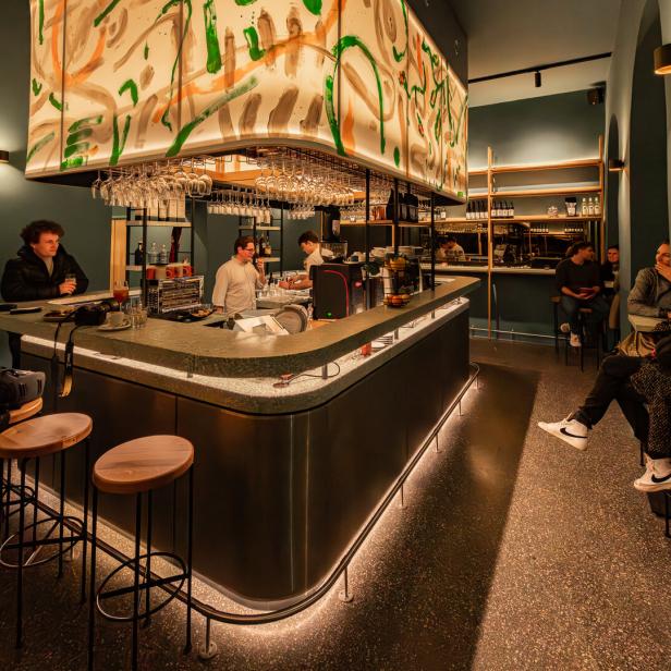 Gäste sitzen an der Bar eines modern gestalteten Cafés.