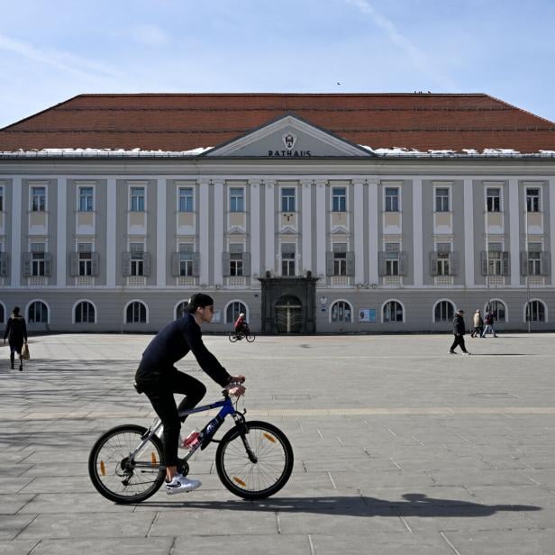 Ein Radfahrer fährt über den Platz vor dem Rathaus.