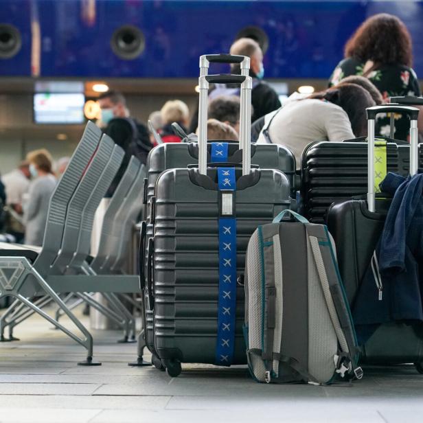 Mehrere Gepäckstücke stehen in einem Wartebereich am Flughafen.