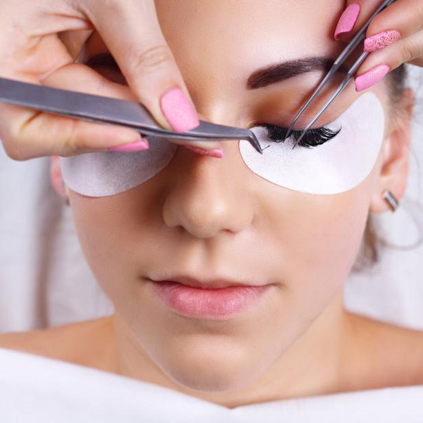 Frau lässt sich die Wimpern machen.