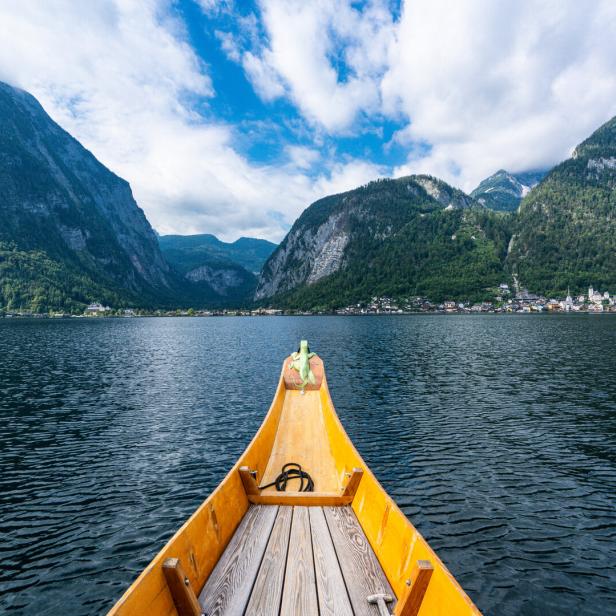 Blick von einem gelben Boot auf den Hallstätter See und die umliegenden Berge.