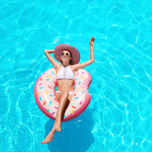 Frau im Pool auf Schwimmreifen - Abkühlung im Sommer.