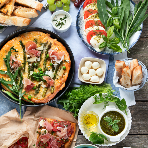 Eine Auswahl an italienischen Speisen, darunter Pasta, Frittata und Caprese.