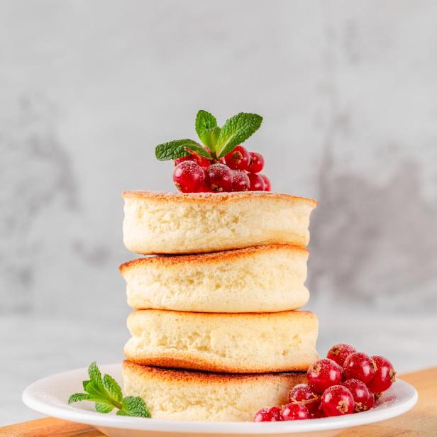 Ein Stapel Soufflé-Pfannkuchen, garniert mit roten Johannisbeeren und Minze.
