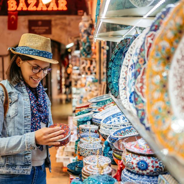 Eine Touristin betrachtet eine Dose in einem Souvenirladen.
