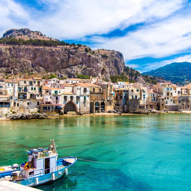 Ein Fischerboot liegt vor der Küste von Cefalù in Sizilien.
