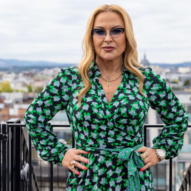 Anastacia posiert auf einer Dachterrasse mit Blick auf die Stadt.