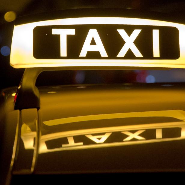 Ein leuchtendes Taxi-Schild bei Nacht.