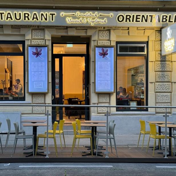 Die Fassade des Restaurants „Orientable“ mit Tischen im Außenbereich.