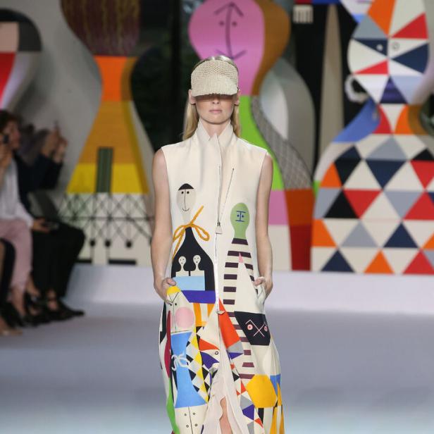 Eine Frau präsentiert ein Kleid mit bunten, abstrakten Mustern von Akris-Chefdesigner Albert Kriemler.