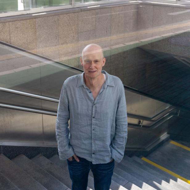 Arno Geiger steht vor einer Treppe.