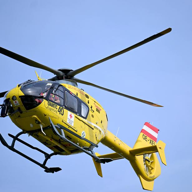 Ein gelber Rettungshubschrauber des ÖAMTC im Flug.