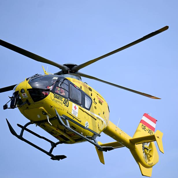 Ein gelber Rettungshubschrauber des ÖAMTC im Flug.