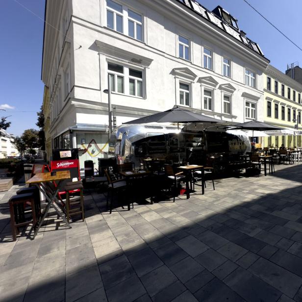 Ein Imbisswagen mit Tischen und Stühlen steht auf der Takan Streetfood.