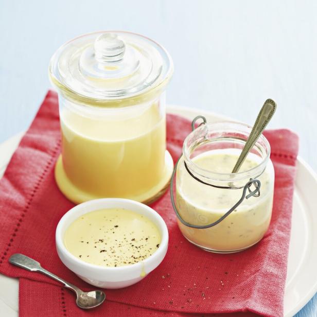 Drei Schalen mit Sauce Hollandaise und Beurre Blanc auf einem roten Tuch.