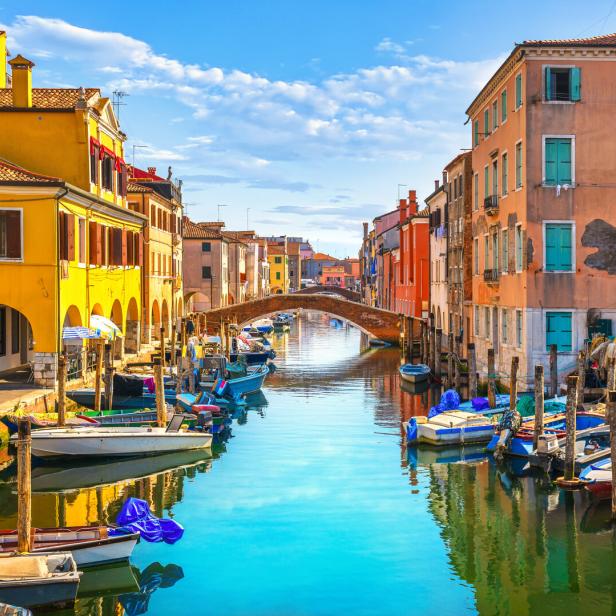 Ein Kanal in Chioggia, gesäumt von bunten Häusern und kleinen Booten.