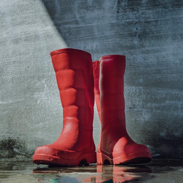 Rote Gummistiefel stehen im Wasser