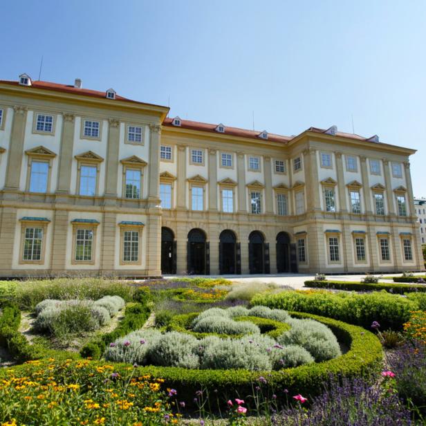 Das Gartenpalais Liechtenstein mit einem kunstvoll angelegten Garten im Vordergrund.