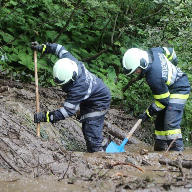 Feuerwehrleute graben im Schlamm