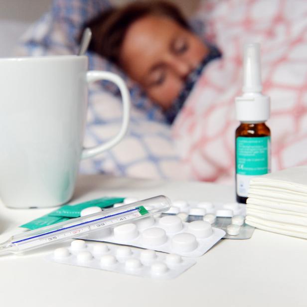 Eine kranke Frau liegt im Bett.