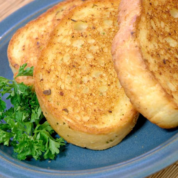 Ein blauer Teller mit geröstetem Brot und Petersilie.