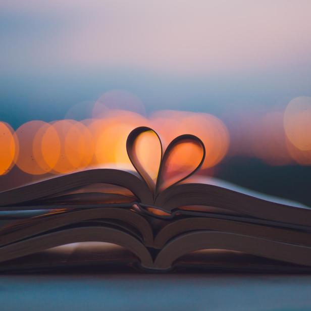 Ein Buch liegt aufgeschlagen da, die Seiten formen ein Herz.