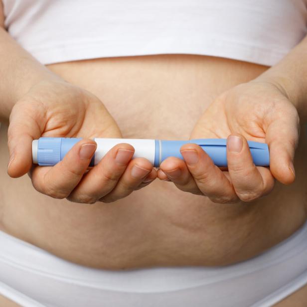 Eine Frau hält eine Abnehmspritze in der Hand.