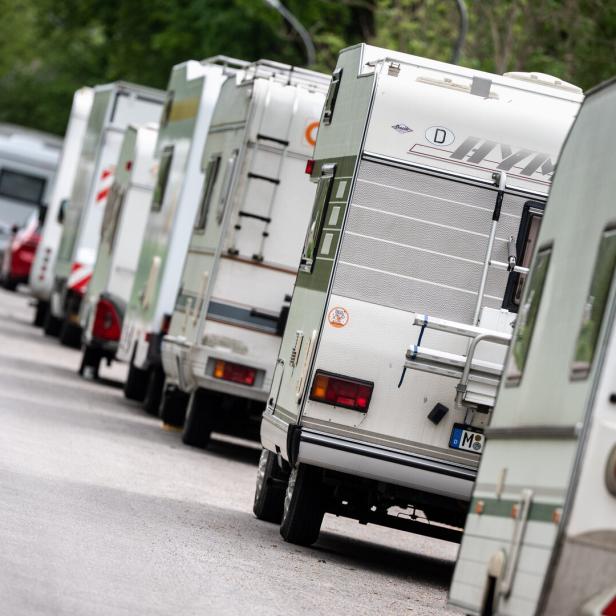 Wohnmobil und Wohnwagen in einer langen Reihe auf der Straße
