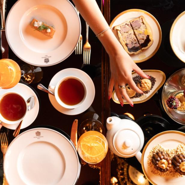 Tee, Orangensaft und verschiedene Speisen sind für eine Teestunde auf einem Tisch angerichtet.