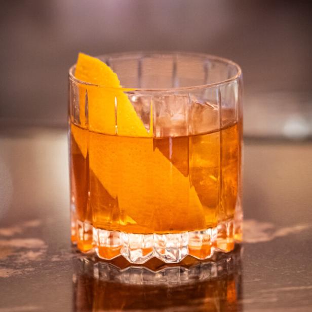 Ein „Salted Maple Old Fashioned“-Cocktail mit einer Orangenzeste.