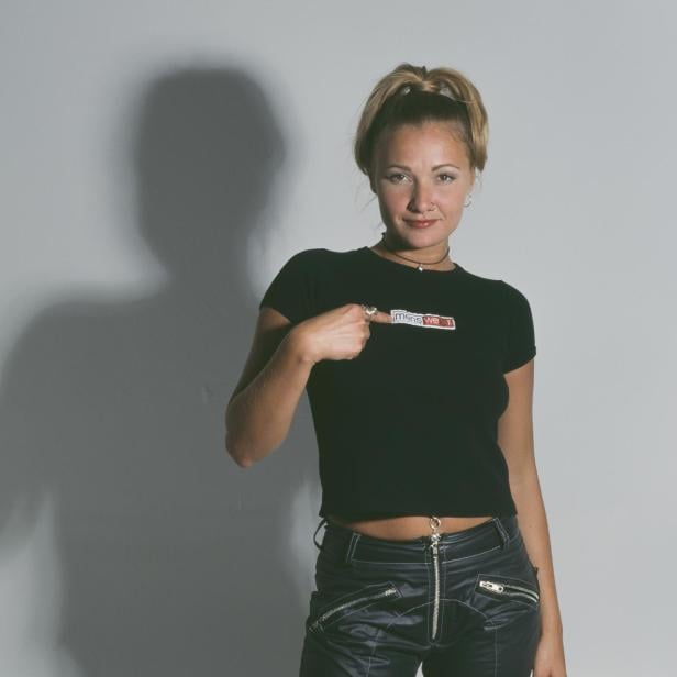 Eine junge Frau mit Nasenring und einem T-Shirt mit der Aufschrift „Menswear“.