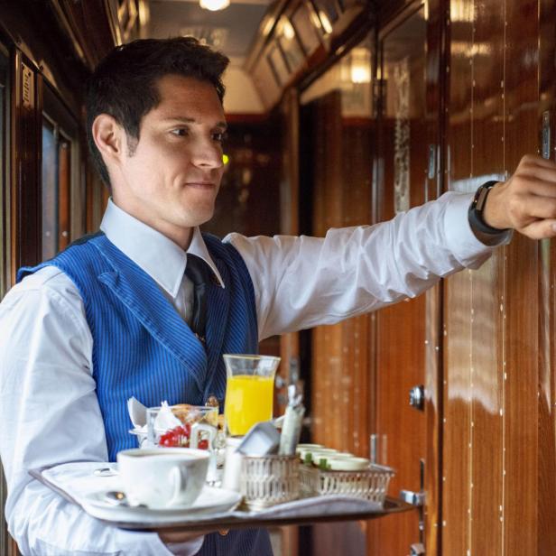 Ein Kellner serviert im Belmond Venice Simplon Orient Express Frühstück.