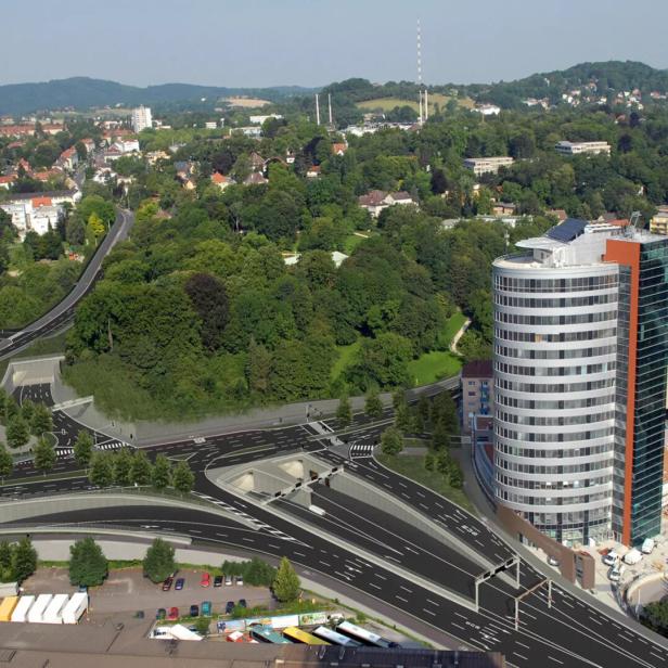 Luftaufnahme einer Stadtlandschaft mit einem modernen Bürogebäude und einer Autobahn mit Tunneln.