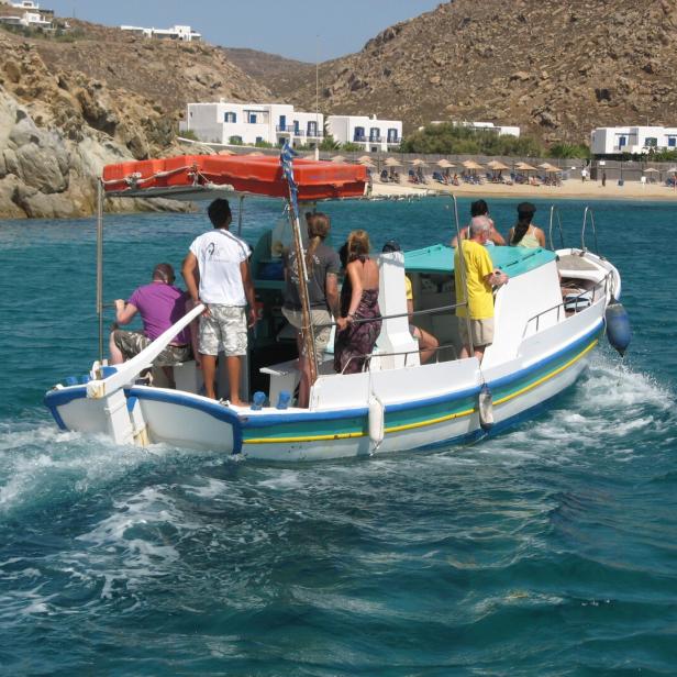 Kleines Taxiboot im Meer vor Mykonos mit wenigen Passagieren