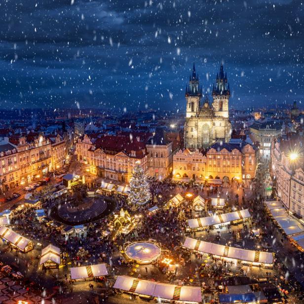 Ein Weihnachtsmarkt auf dem Altstädter Ring in Prag im Schneefall.