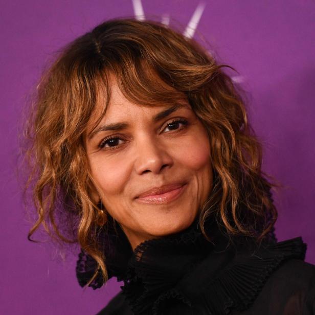 Ein Porträt von Halle Berry vor einem violetten Hintergrund.