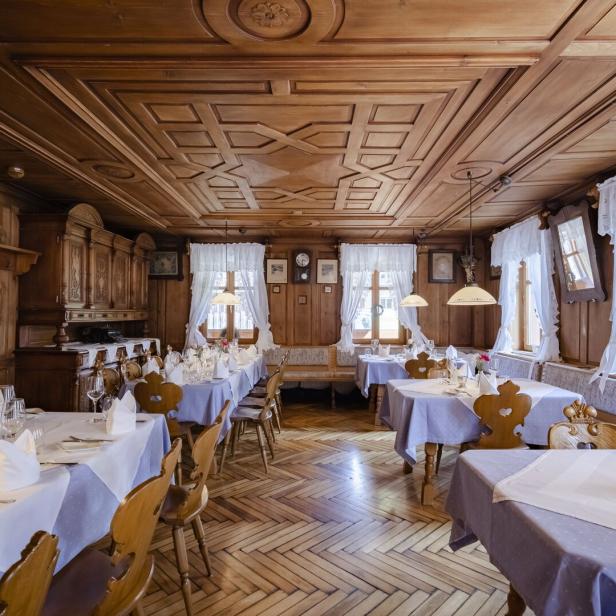 Ein Speisesaal mit Holztäfelung und gedeckten Tischen für ein festliches Essen.