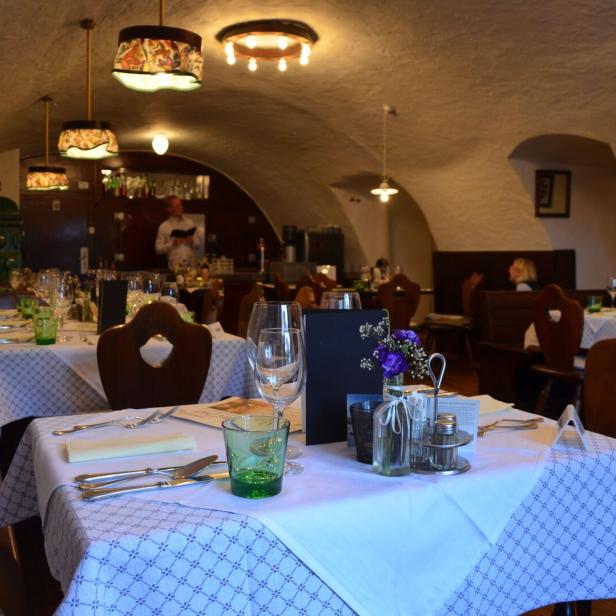 Ein gedeckter Tisch in einem Restaurant mit Gewölbedecke.
