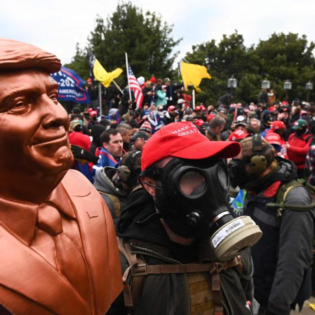 (FILES) A supporter of US President Donald Trump wears a gas mask and holds a bust of him after he and hundreds of others stormed stormed the Capitol building on January 6, 2021 in Washington, DC. Donald Trump hits the campaign trail in the first-in-the-nation presidential nominating state of Iowa on January 6, 2024 as Americans mark the third anniversary of the deadly assault on the US Capitol by a mob of his supporters. People watched in horror on January 6, 2021, as TV images were beamed into homes nationwide showing rioters -- egged on by the ex-president and fueled by his false claims of voter fraud -- storming the seat of US democracy to halt the transfer of power. (Photo by ROBERTO SCHMIDT / AFP)